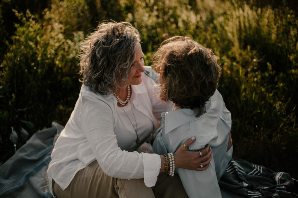 Une séance couple dans la nature de deux femmes amoureuses qui se regarde, sous le soleil couchant.