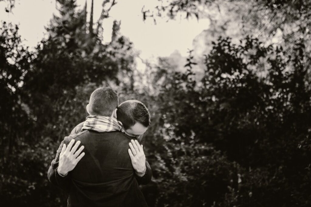 Séance couple d'hommes entrelaçés dasn la nature. Photo noir et blanc.