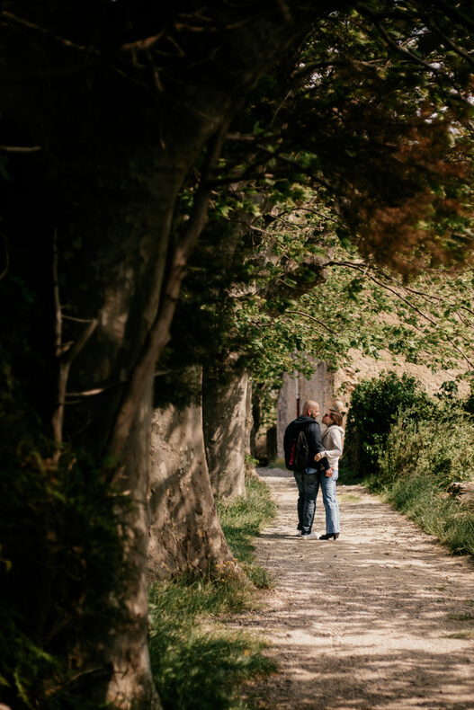 Dans une allée, sous l'ombre des arbres le couple se parle Séance couple par @sophiebacherephotos. La séance photo de couple sur les hauteurs de la clappe près de Narbonne Plage dans l'Aude en Occitanie, France