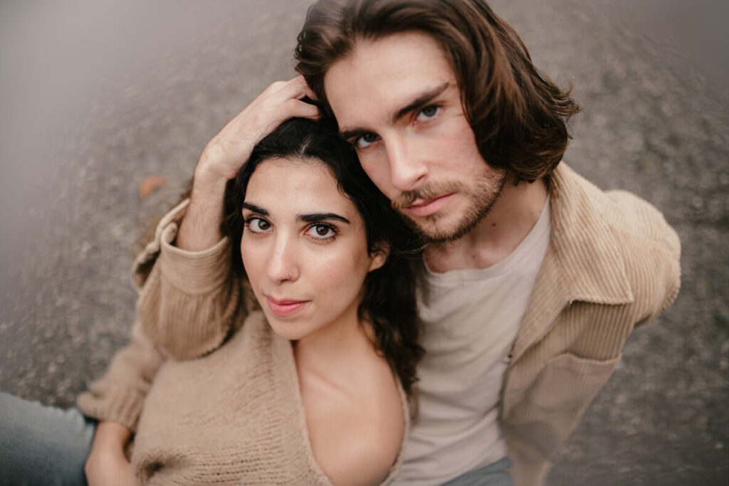 Séance couple, assis tous les deux sur la route et ils regardent la caméra