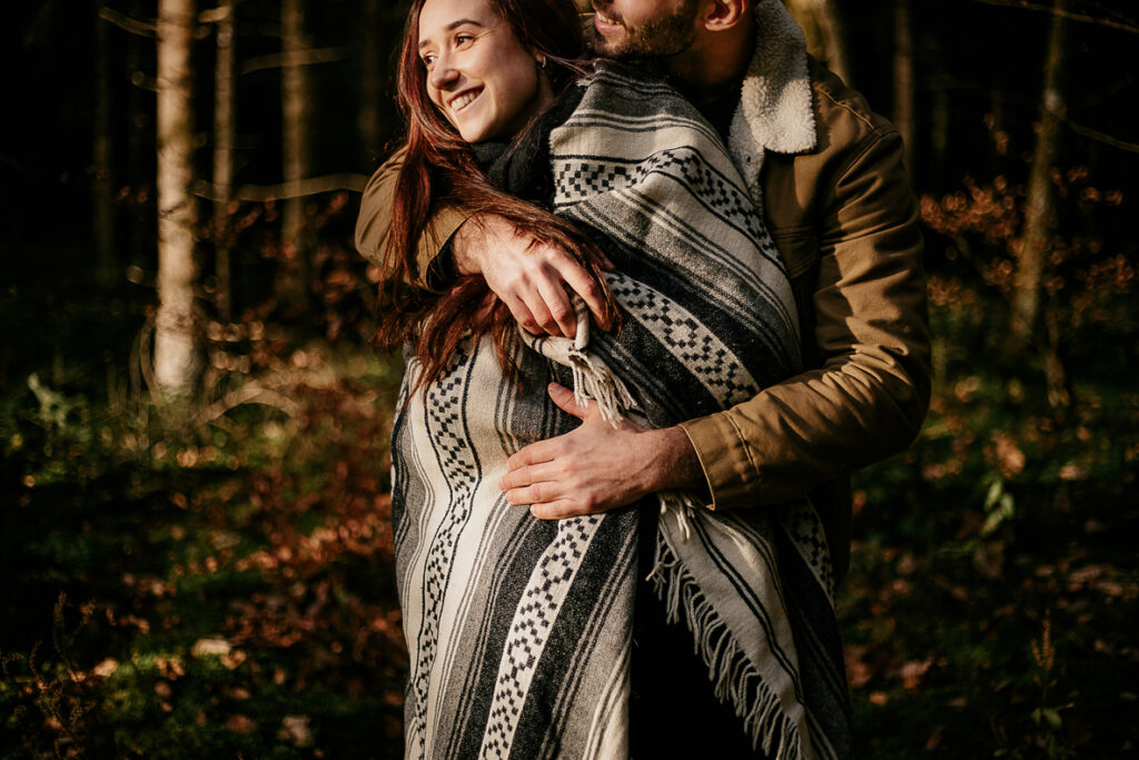 photo prise par @sophiebacherephotos. Séance couple au coeur de la montagne noire dans l'Aude. La photo montre le couple dans la forêt, la lumière est juste sur le couple entrelacée.