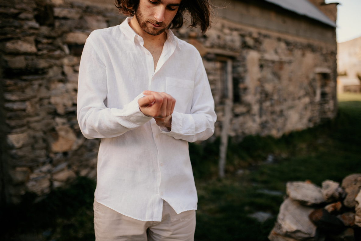 Photo prise par @sophiebacherephotos, marié boutonnant sa chemise