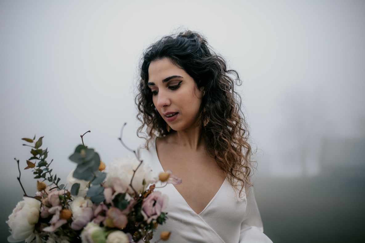 Photo prise par @sophiebacherephotos. Portrait de la jeune mariée avec un aperçu de son bouquet