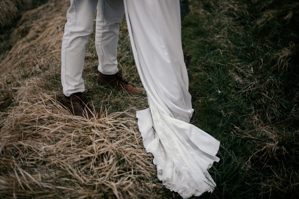 Photo prise par @sophiebacherephotos. Plan où l'on voit les pieds du marié et la traine de la robe de la mariée