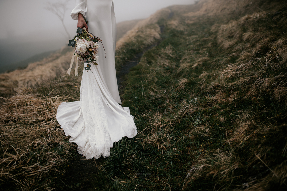 Photo prise par @sophiebacherephotos. plan sur la robe de la mariée et sur son bouquet