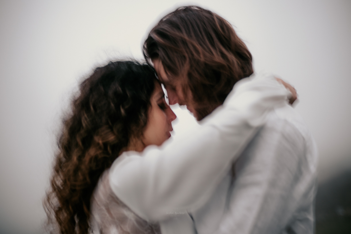 Photo prise par @sophiebacherephotos. Photo représentant un jeune couple de mariés lors de leur elopment dans les Pyrénées. La photo montre le couple face à face la femme bras autour du cou de l'homme.