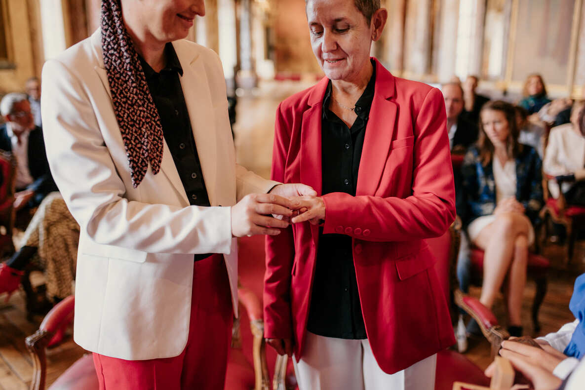 Photo prise par @sophiebacherephotos. La photo montre le couple de futures mariées s'échangeant les anneaux.