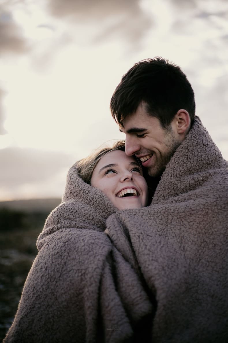 Photo prise par @sophiebacherephotos. Séance couple sur les hauteurs de la Clape à Narbonne Plage dans l'Aude en Occitanie. La photo montre le couple dans la couverture se regardant.