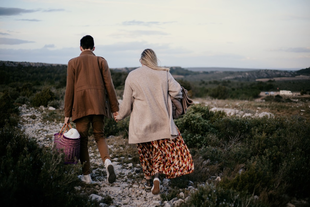 Séance couple par @sophiebacherephotos. La séance photo de couple sur les hauteurs de la clappe près de Narbonne Plage. La photo montre le couple en fin de journée marchant vers leur voiture.