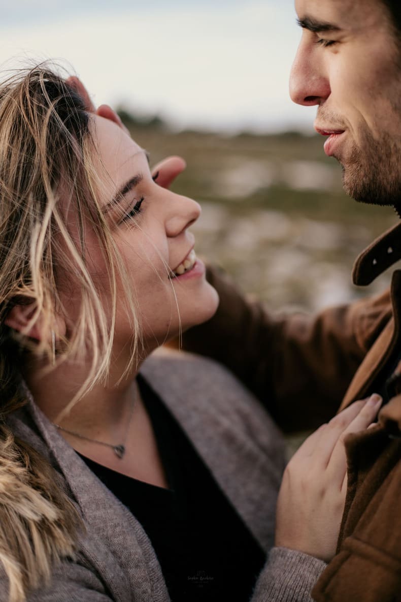 Photo prise par @sophiebacherephotos. Séance photo de couple sur les hauteurs de la Clape avec vue sur la plage de Narbonne Plage dans l'Aude en Occitanie. La photo montre un plan rapprocher du couple où l'on voit la femme sourire en regardant l'homme.