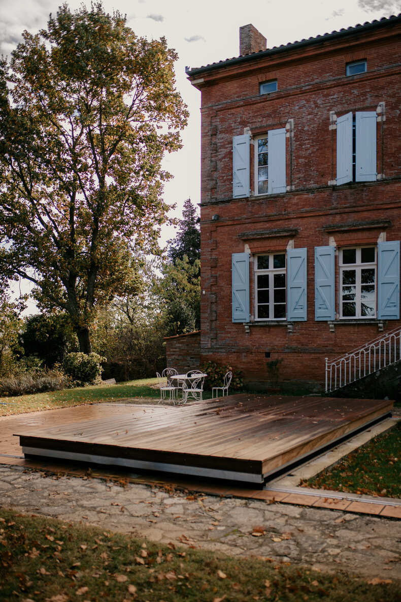 Photo prise par @sophiebacherephotos. La photo montre une façade avec la piscine du Château de Puydaniel en automne