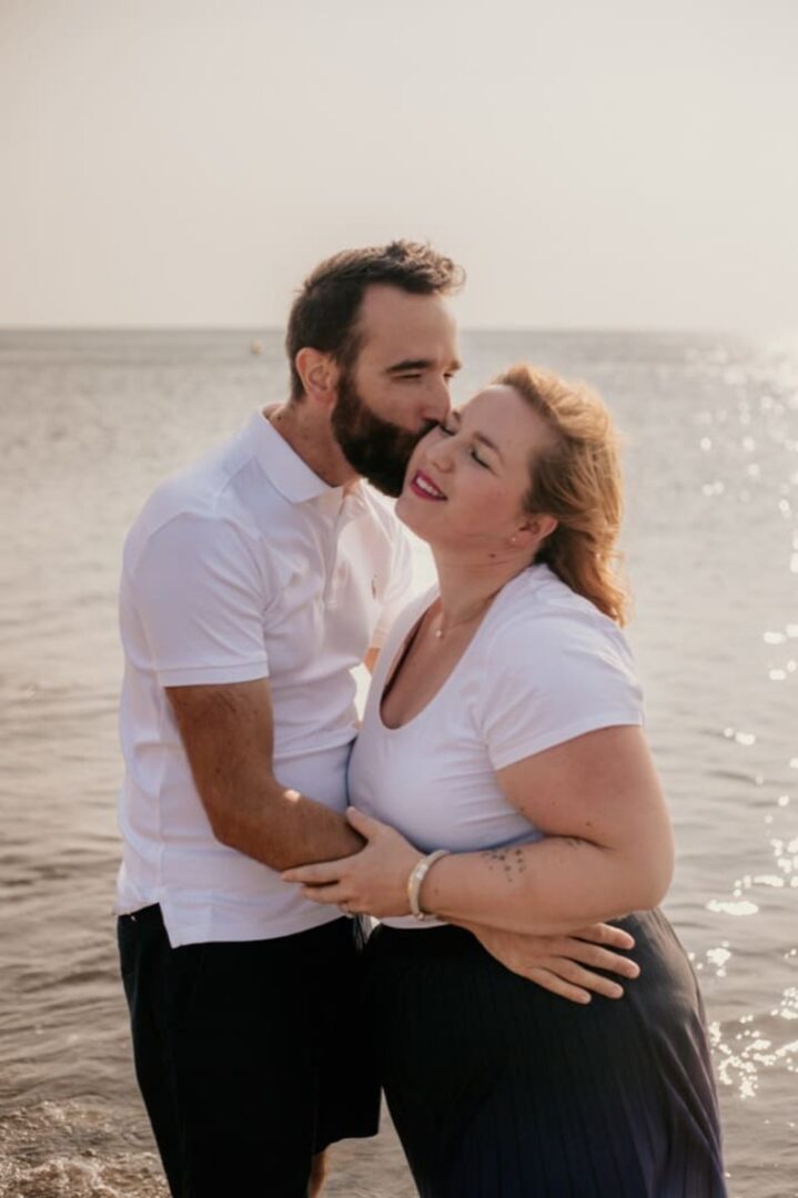 Photo prise par @sophiebacherephotos. La photo montre un couple au bord de l'eau sur la plage