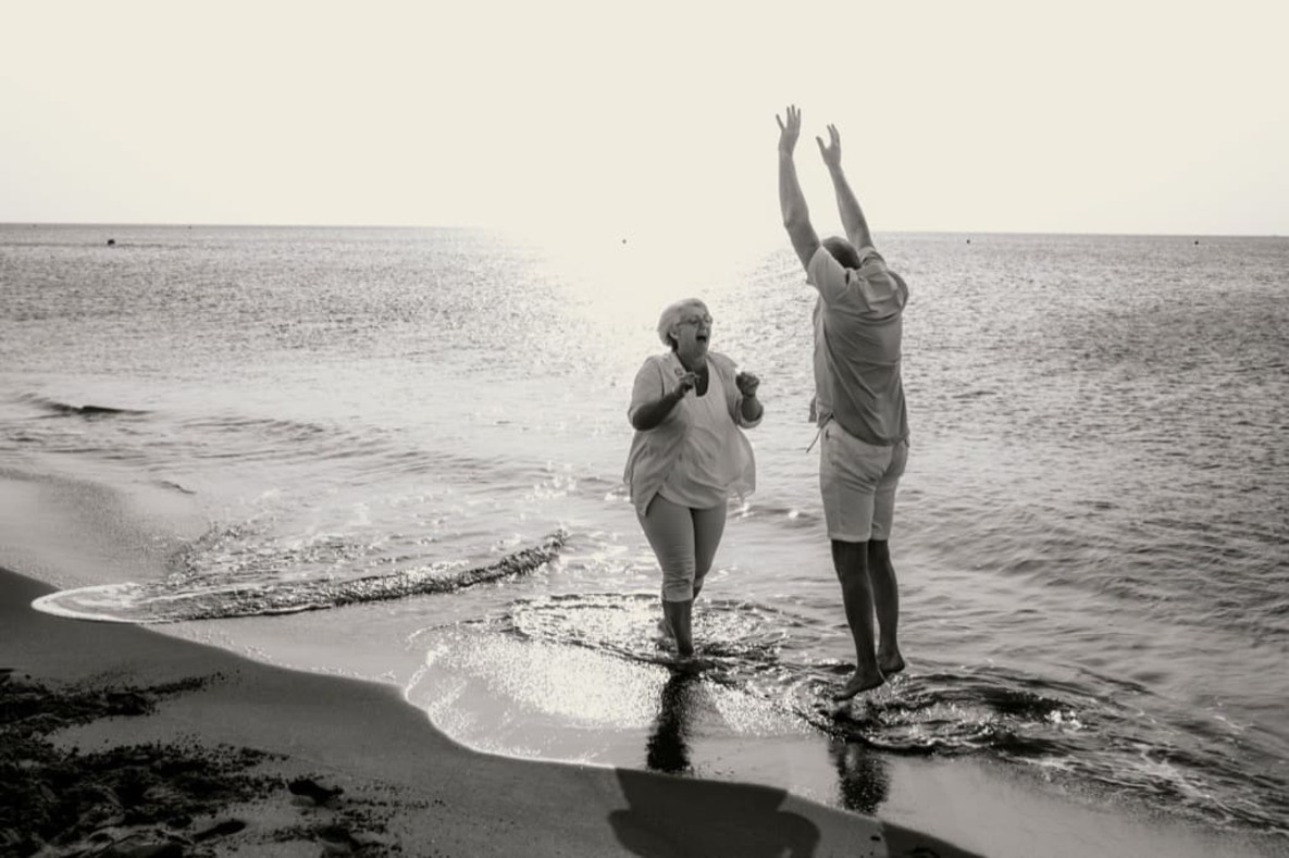 Photo prise par @sophiebacherephotos. La photo montre un couple dansant dans les vagues de la mer.