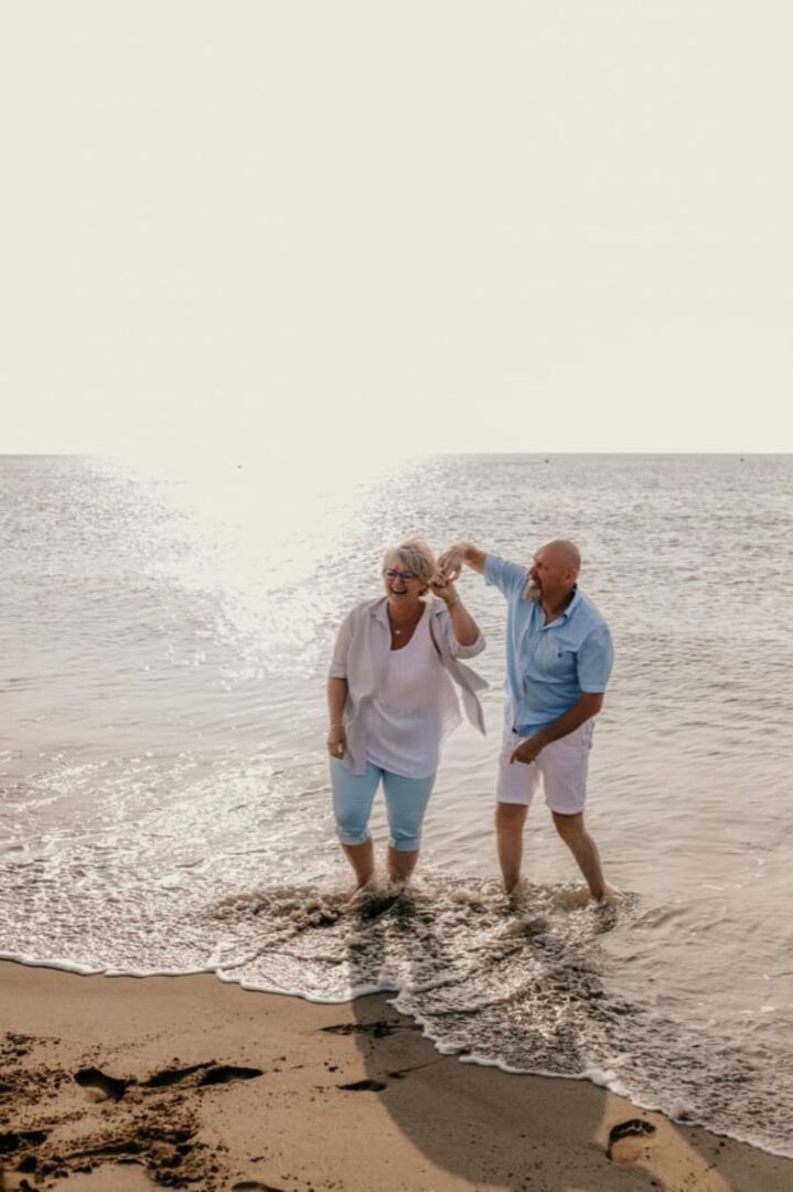 Photo prise par @sophiebacherephotos. La photo montre un couple dansant dans les vagues de la mer.