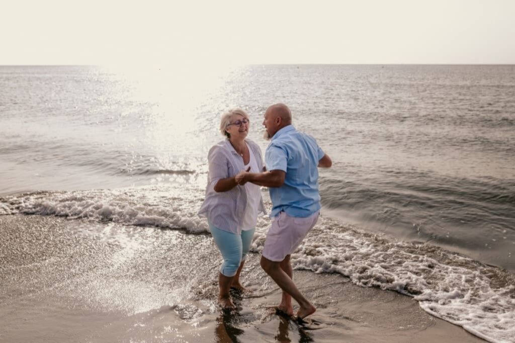 Photo prise par @sophiebacherephotos. La photo montre un couple dansant dans les vagues de la mer.