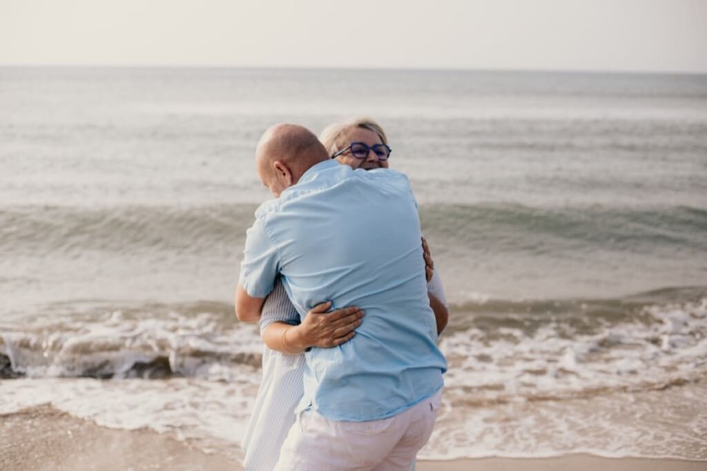Photo prise par @sophiebacherephotos. La photo montre un couple se tenant dans les bras face à mer