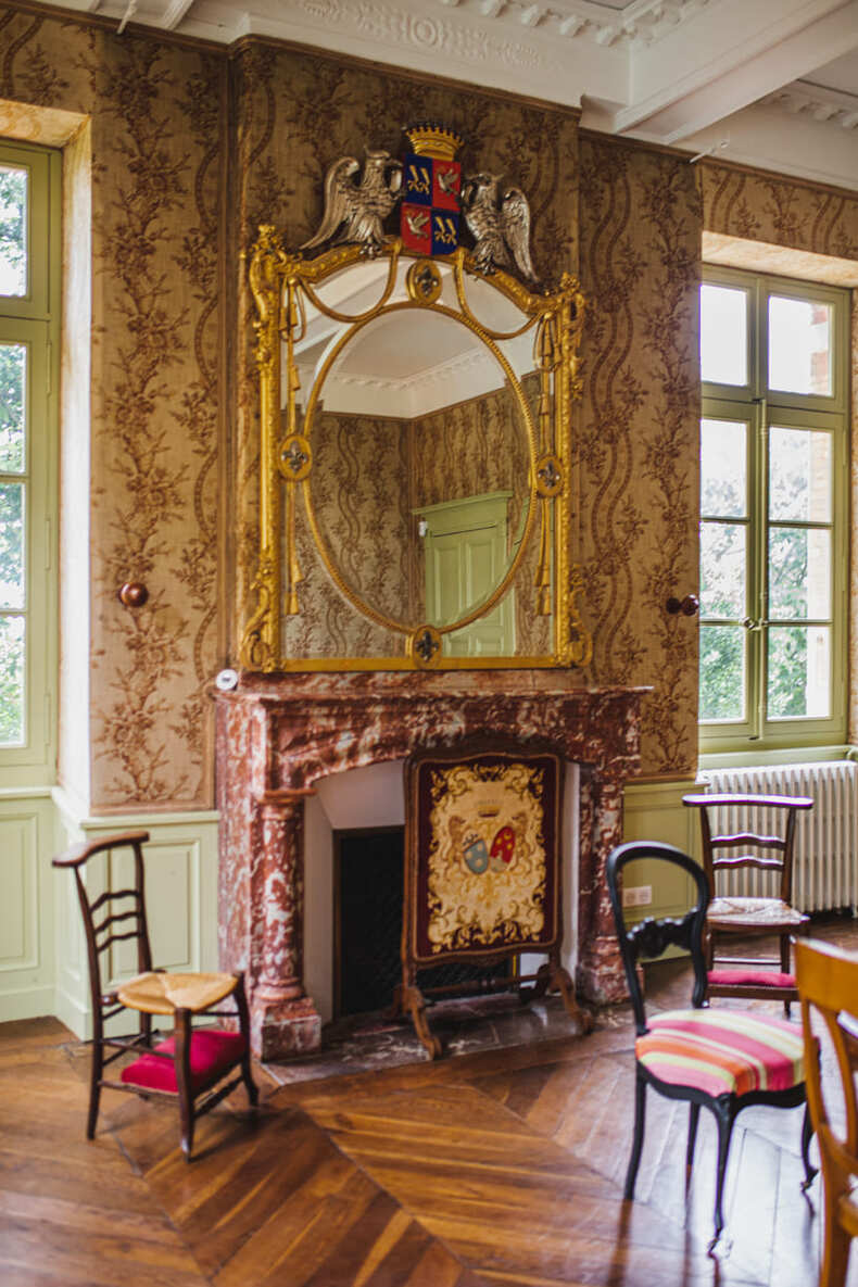 Photo prise par @sophiebacherephotos. La photo montre une pièce avec une cheminée Empire du Château de Puydaniel