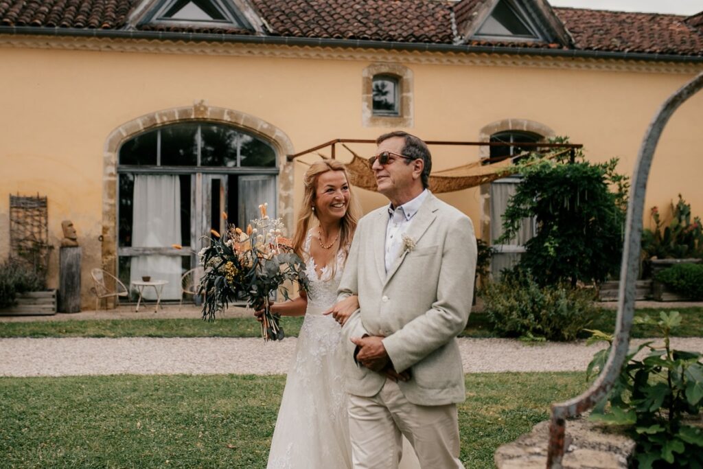 La mariée au bras de son père au Château Lacoste à Lupiac dans le jardin
