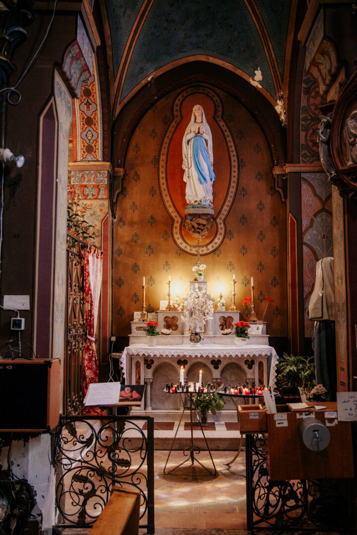 photo prise par @sophiebacherephotos. La photo montre le couple assis sur une rambarde en pierre, en fond les Pyrénées.